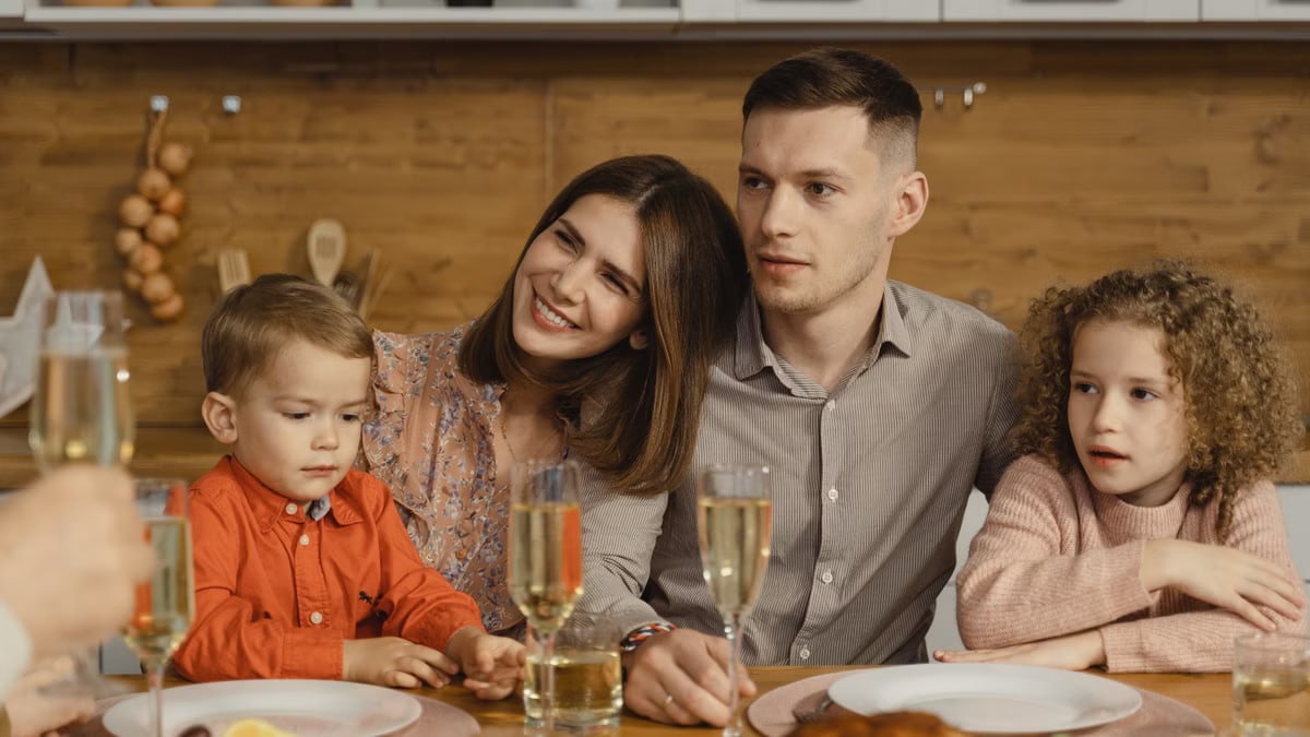 A joyful family gathers for a festive dinner, exchanging warmth and togetherness.